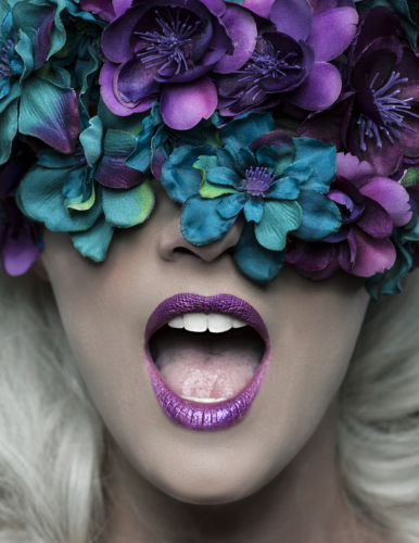 beauty image of woman with turquoise and purple flowers and lipstick and mouth open